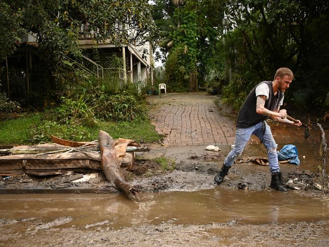 LISMORE, AUSTRALIA - MARCH 29: Eli Roth clears mud and debris from a drain outside his house on March 29, 2022 in Lismore, Australia. Evacuation orders have been issued for towns across the NSW Northern Rivers region, with flash flooding expected as heavy rainfall continues. It is the second major flood event for the region this month. (Photo by Dan Peled/Getty Images)