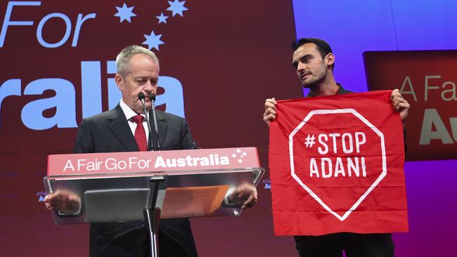 An 'Anti-Adani' protester on stage as Australian Opposition leader Bill Shorten speaks during day one of the Labor Party National Conference in Adelaide last December. Picture: AAP/Lukas Coch