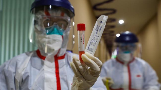 Medical workers testing for coronavirus at a quarantine zone in Wuhan. Picture: AFP