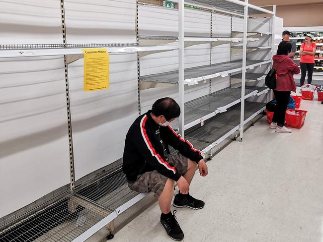 People waiting in the toilet paper aisle for a delivery of toilet paper, paper towel and pasta at Coles Supermarket, Epping in Sydney, Friday, March 20, 2020. Supermarkets have been struggling to keep up with demand for products such as toilet paper in recent days, as panic buying as a result of the Covid-19 pandemic has resulted in people purchasing far more than usual. Supermarkets have put in place limits on the quantity people can purchase of many everyday items. (AAP Image/James Gourley) NO ARCHIVING