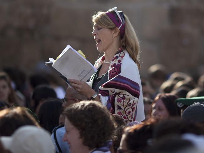 FILE - In this Monday, Nov. 4, 2013, file photo, a Jewish woman wears a prayer shawl as she prays at the Western Wall, the holiest site where Jews can pray in Jerusalem's Old City. Israeli Prime Minister Benjamin Netanyahu is advancing a plan to allow non-Orthodox Jewish prayer at the Western Wall in Jerusalem, a move advocates say would mark unprecedented government support for liberal streams of Judaism. According to the government proposal Israel would build a new plaza for mixed gender prayer at the Western Wall, adjacent to the Orthodox prayer plaza. (AP Photo/Ariel Schalit, File)