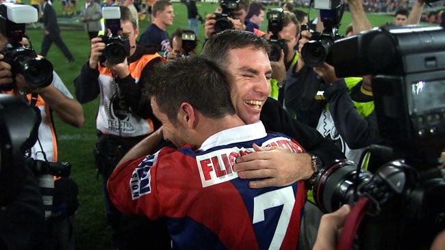 Coach Michael Hagan and skipper Andrew Johns embrace after the Knights’ upset win. Picture: Phill Hillyard.