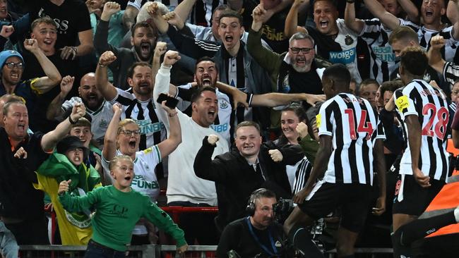 Newcastle United players celebrate a goal against Liverpool.