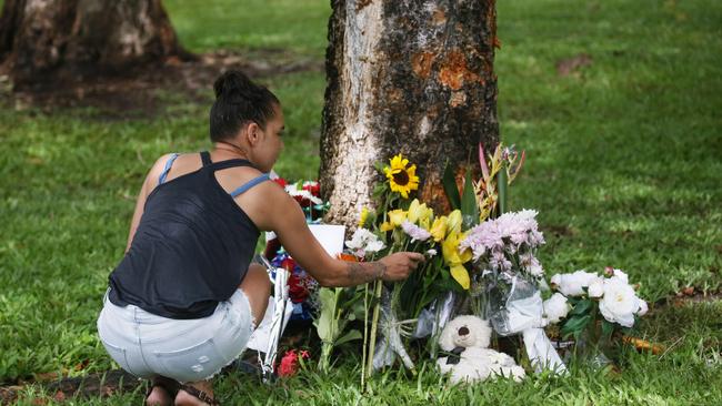 Scene of a fatal traffic crash at Manoora, where a stolen Toyota Yaris driven by the boy who was 14 at the time, left Pease Street near the Saltwater Creek bridge and crashed into a tree. Denise Weazael of Manoora lays some flowers at the scene of the crash. Picture: Brendan Radke