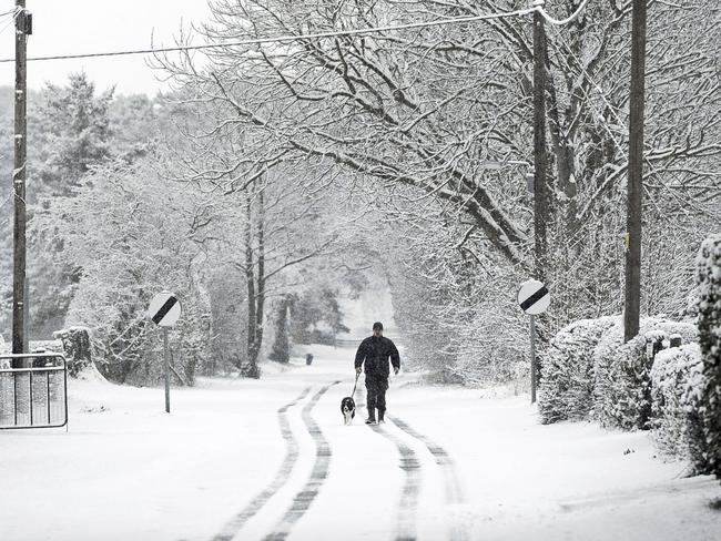 A man walks his dog down a snow covered lane near Malton in northern England, as heavy snowfall is affecting roads across the Britain on Tuesday morning after several centimetres fell in some parts overnight. Tuesday Feb. 27, 2018. Police forces have reported “tricky” driving conditions, with forecasters expecting the wintry weather to continue for the next few days. Picture: AP