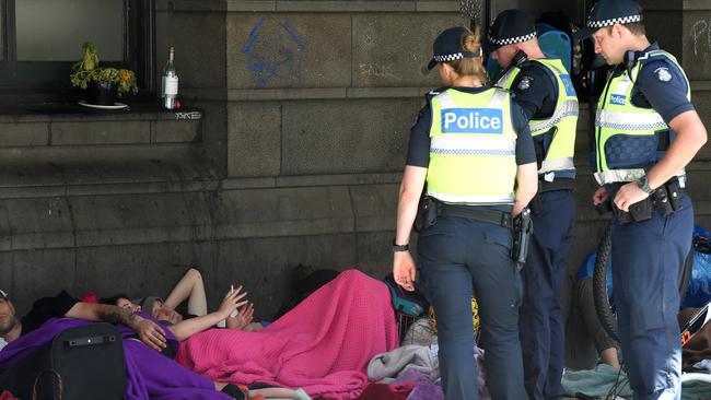 Officers speak to one man who then throws his alcohol in the bin. Picture: Nicole Garmston