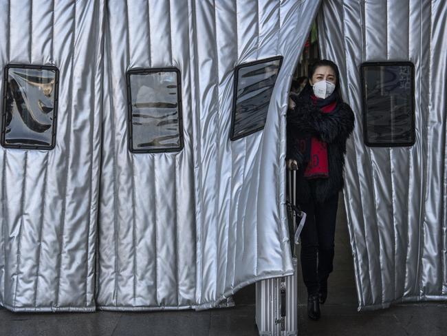 A Chinese woman wearing a protective mask as she leaves a Beijing railway station. Picture: Kevin Frayer/Getty