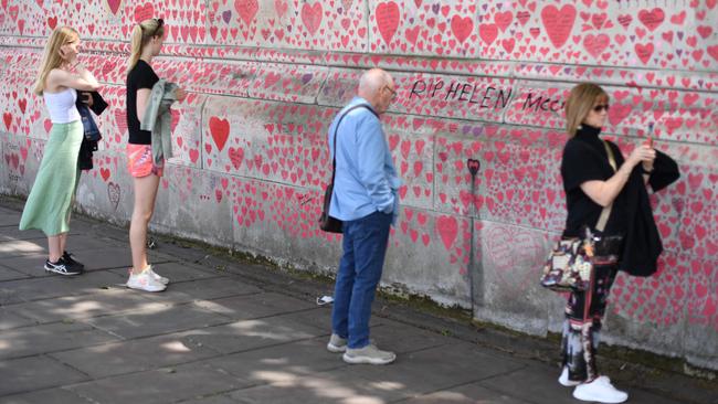 People read the messages on the National Covid Memorial Wall at the Embankment on the south side of the River Thames in London. Picture: AFP