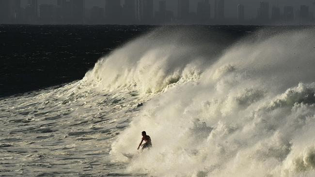 A surfer at Snapper Rocks on Sunday with the Gold Coast skyline in the background. Picture: Lyndon Mechielsen