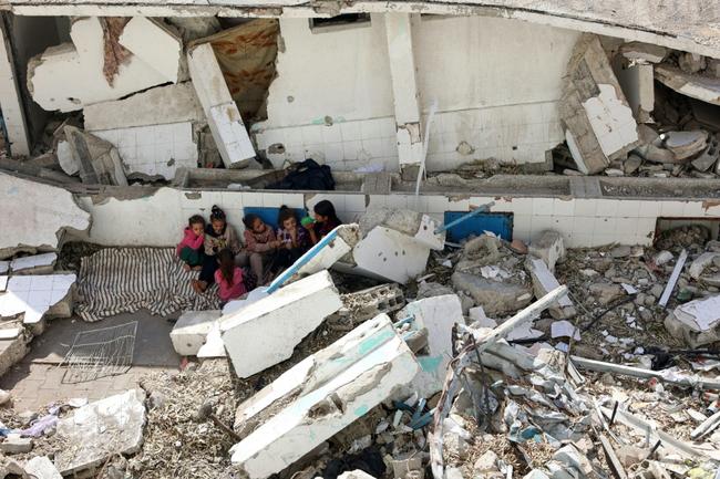 Displaced Palestinian children sit among the rubble of a destroyed building in the Nasser district of Gaza City, in the Palestinian territory's north