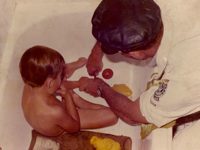 Police rescuer helps a child who has his finger stuck in the bath plug hole. These were common in the 1970s. Picture: Supplied