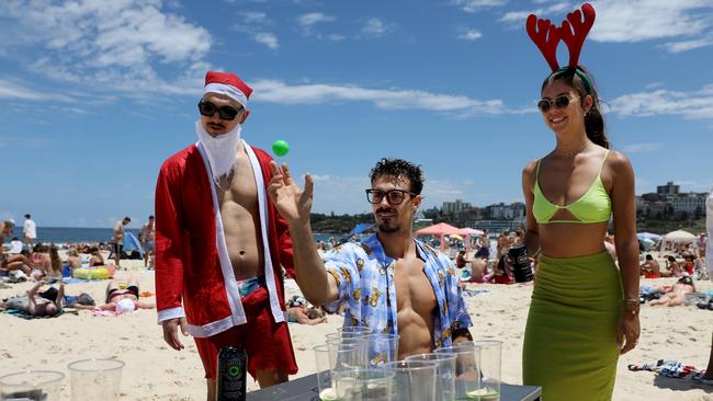 French travellers, from left, Remi Aubriot, 23, Liam Rouille, 23 and Emma Manoury, 24, play beer pong at Bondi Beach in Sydney’s east. Picture: Jane Dempster