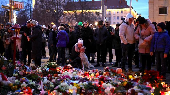 People lay flowers at a makeshift memorial near the shuttered Christmas market the day after a terror attack that has left five people dead. Picture: Getty