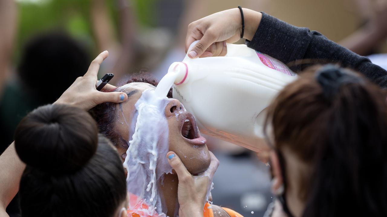 A protester is doused with milk after exposure to tear gas outside. Picture: Carlos Gonzalez/Star Tribune via AP