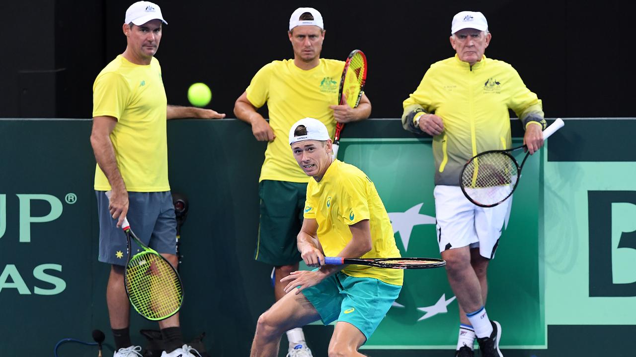 Australian tennis players Jaymon Crabb, Lleyton Hewitt, and Tony Roche look on to Alex de Minaur during a training session. Picture: Dave Hunt/AAP