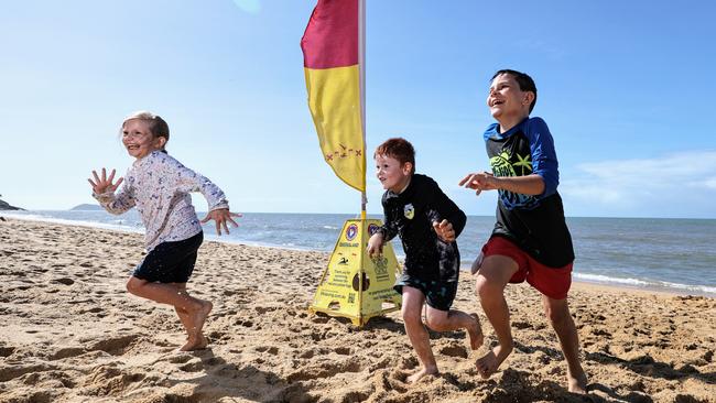 Wet and miserable weather is expected to clear into the weekend, heating temperatures up. Christmas Day is expected to be 34 degrees with clear, sunny skies ideal for the beach and pool. Evie Roach, 7, her cousin Jacob Toth, 6, and brother Archie Roach, 10, were captured in winter making the most of the sun at the Trinity Beach from the shoreline. Picture: Brendan Radke