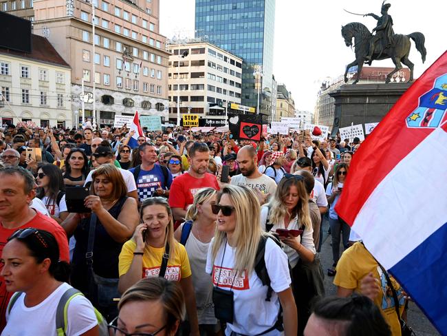 People hold placards as several thousand people protest against measures imposed by the authorities. Picture: AFP