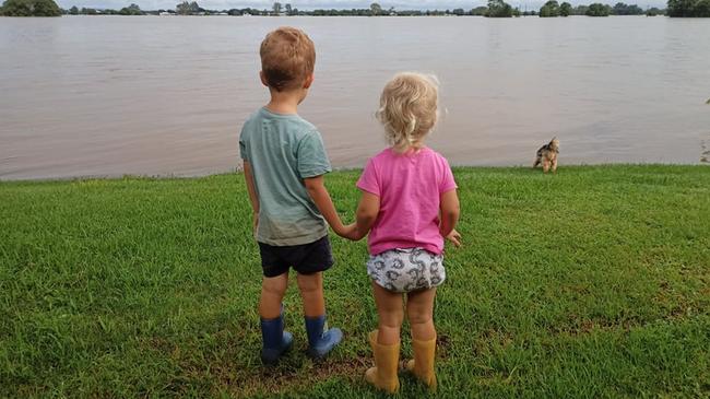 Mel and Troy Eggins’ children look out over their family’s flood-ravaged farm. Picture: Mel Eggins