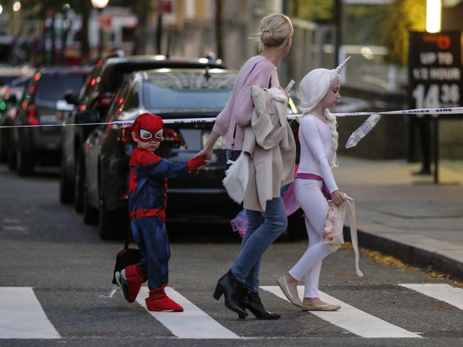 Kids in Halloween costumes cross the street near the scene where a man driving a rental truck struck and killed eight people on a jogging and bike path in Lower Manhattan. Picture: Getty