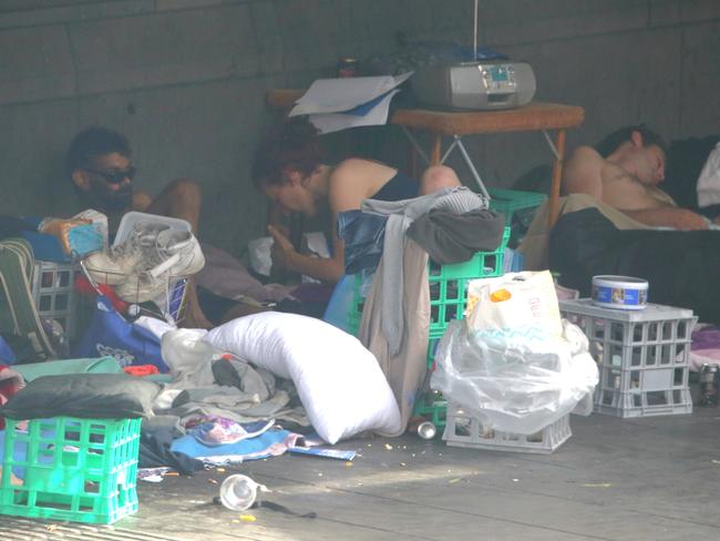 A woman smokes a bong among the homeless camped outside Flinders St Station. Picture: Ian Currie