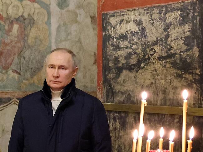 Russian President Vladimir Putin stands alone at a mass on Christmas eve in Moscow. Picture: Sputnik/AFP