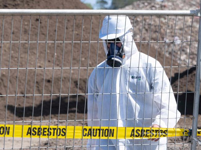 06-03-2024 Workers in protective equipment move contaminated soil with asbestos signs around the building site in Murray Road, Queenscliff. Picture: Brad Fleet