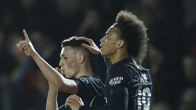 Manchester City's Phil Foden, left, celebrates with his teammate Leroy Sane after scoring his side's third goal during the English FA Cup fifth round soccer match between Newport County and Manchester City at Rodney Parade stadium in Newport, Wales, Saturday, Feb. 16, 2019. (AP Photo/Frank Augstein)