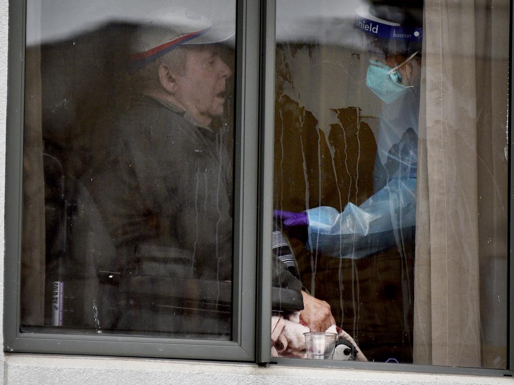 A resident at Arcare Maidstone Aged Care in Melbourne's west is attended to by a medical staff member after the facility went into lockdown.