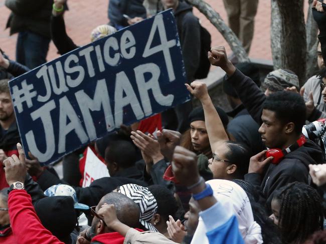 Demonstrators raise their fists in the air at the Government Centre in Minneapolis during a protest over two Minneapolis police officers fatally shooting Jamar Clark. Picture: AP