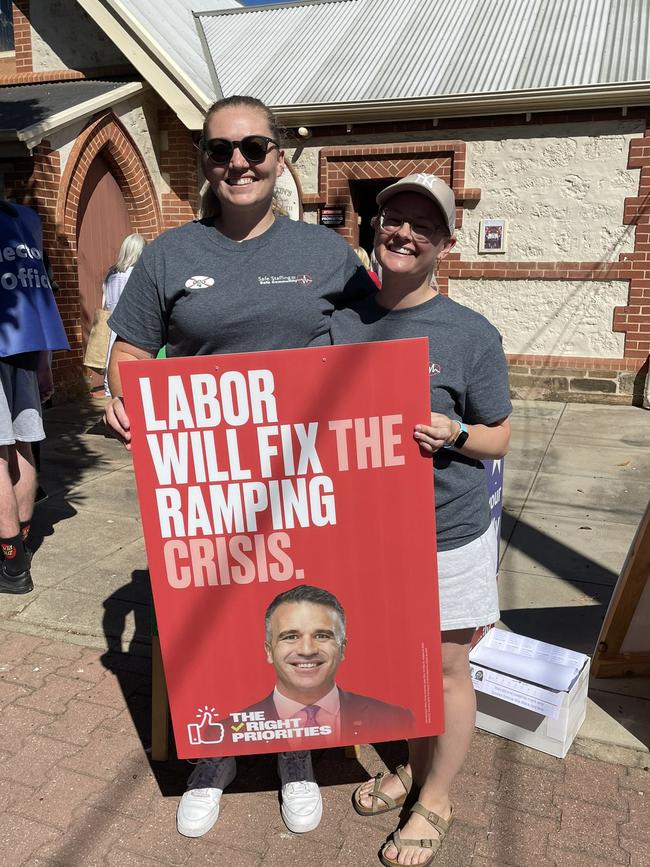 Paramedics Ashleigh Frier and Sian Wanstall with a Labor poster at a polling booth during the state election. Picture: Twitter