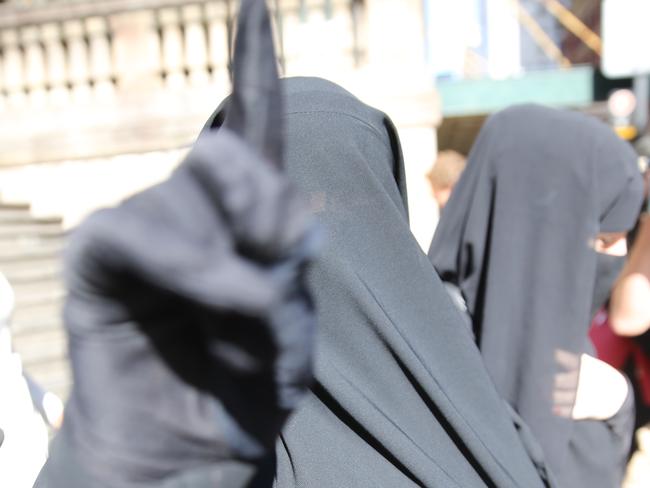 Moutia Elzahed  ( left  giving the IS salute)  the downing centre  after being found guilty ,  a Muslim woman who refused to stand for a Sydney judge and who was charged with "disrespectful behaviour in court". Pic John Grainger