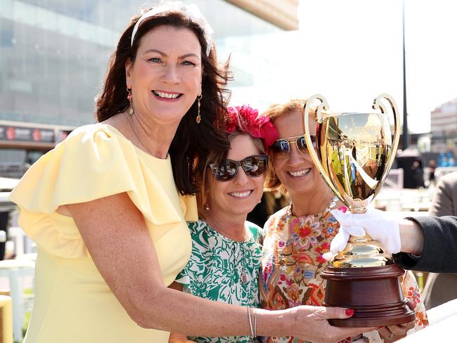 Racegoers pose with The Sportsbet Caulfield Cup. Picture: Getty Images