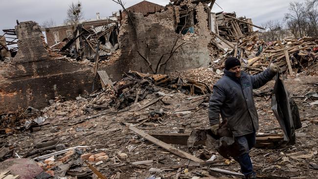 A volunteer clears away rubble from the front of a building that was destroyed by a Russian attack two weeks ago in Kharkiv, Ukraine. Picture: Getty Images