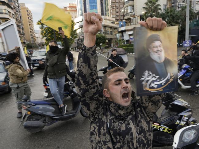 A man celebrates carrying a picture of slain Hezbollah leader Hassan Nasrallah in Dahiyeh, Beirut on Wednesday. Picture: AP Photo