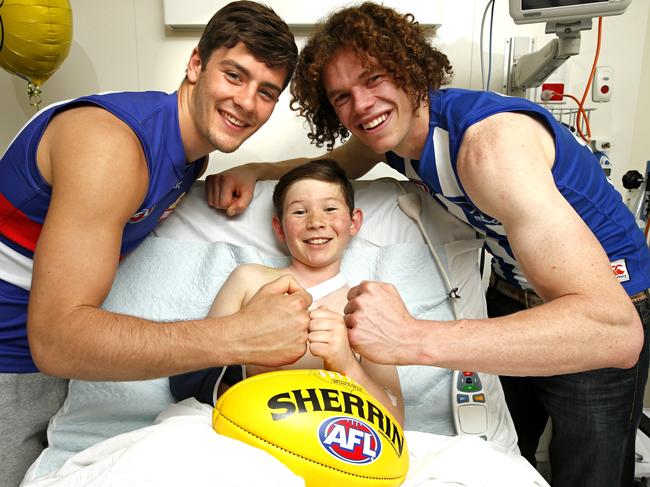 AFL teams to play the Good Friday clash at the MCG, North Melbourne Kangaroos and Western Bulldogs. Players Josh Dunkley from Western Bulldogs and Ben Brown from North Melbourne with Jordan Van de Hoef 10, injured in a motorcycle accident at the Royal Children's Hospital. Picture: David Caird
