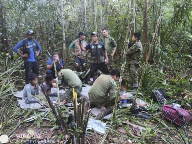 The army assisting the four children. A plane crash triggered the massive rescue operation. Picture: Colombian Presidency / AFP