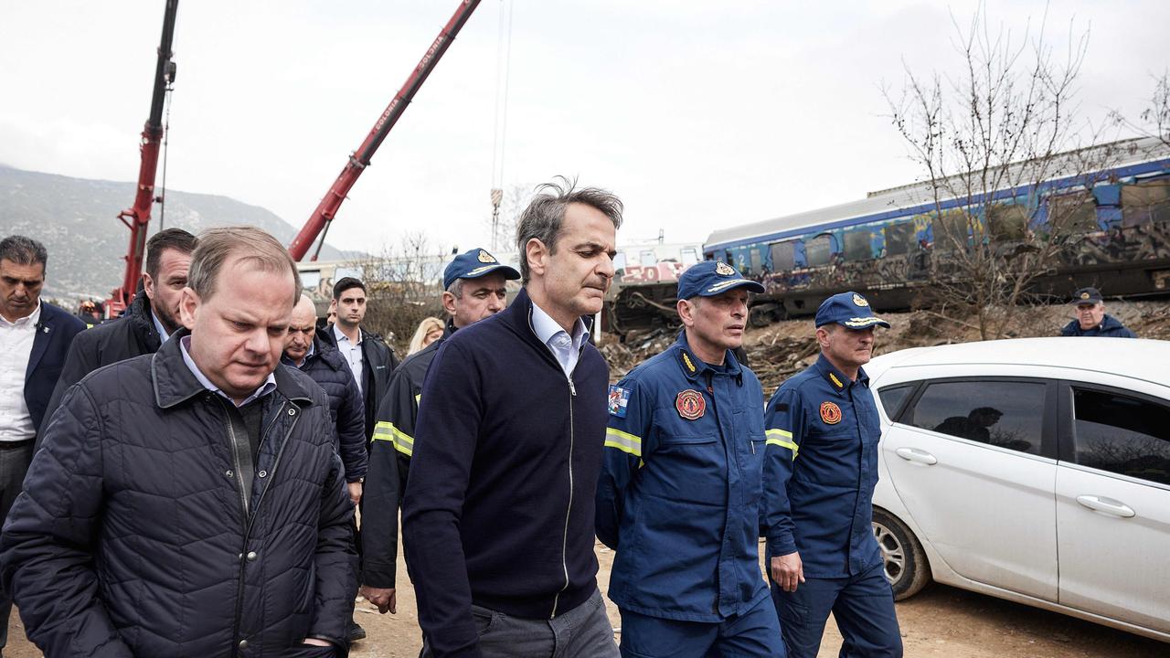 Greek Transport Minister Kostas Karamanls, who resigned, and Greek Prime Minister Kyriakos Mitsotakis visit the crash site. Picture: AFP