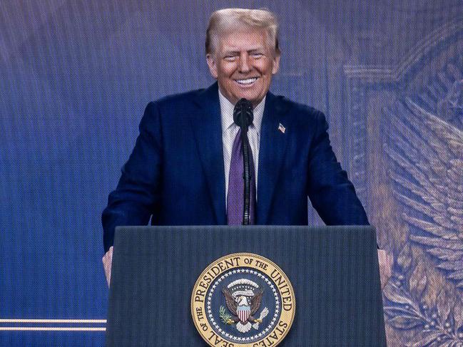 US President Donald Trump is seen on a large screen during his address by video conference at the World Economic Forum (WEF) annual meeting in Davos on January 23, 2025. (Photo by Fabrice COFFRINI / AFP)