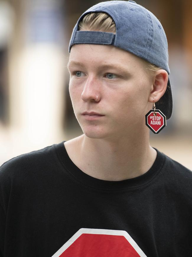 One boy wears an earring with the words “stop Adani.”.