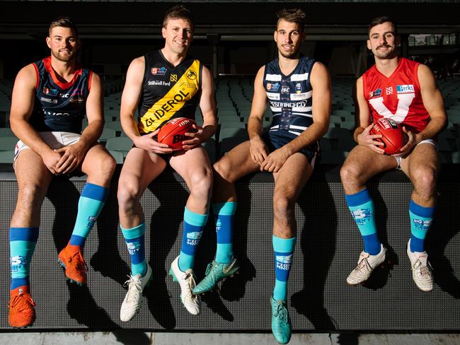 SANFL Norwood's Mitch Grigg, Glenelg's Luke Reynolds, South Adelaide's Tyson Brown and North Adelaide's Alex Spina at Adelaide Oval, wearing blue socks to help raise awareness for MND in Adelaide, Wednesday, June 5, 2019. (The Advertiser/ Morgan Sette)