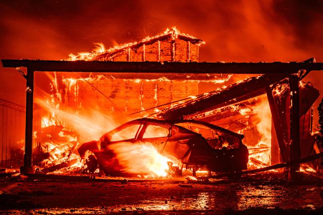 A car and home burn in Altadena. Picture: AFP