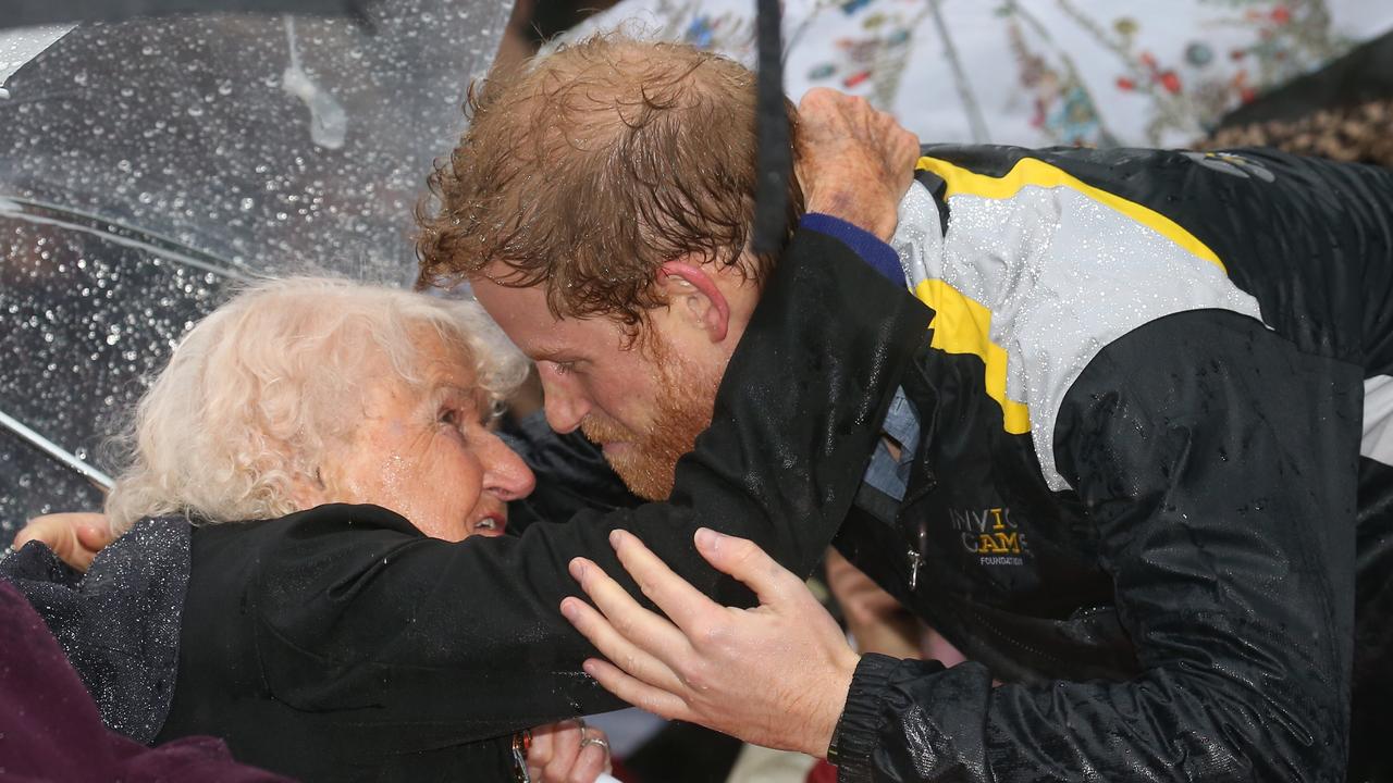 Prince Harry didn’t let the rain stop having a second smooch with Daphne Dunne when he met her again in 2017. Picture: Toby Zerna