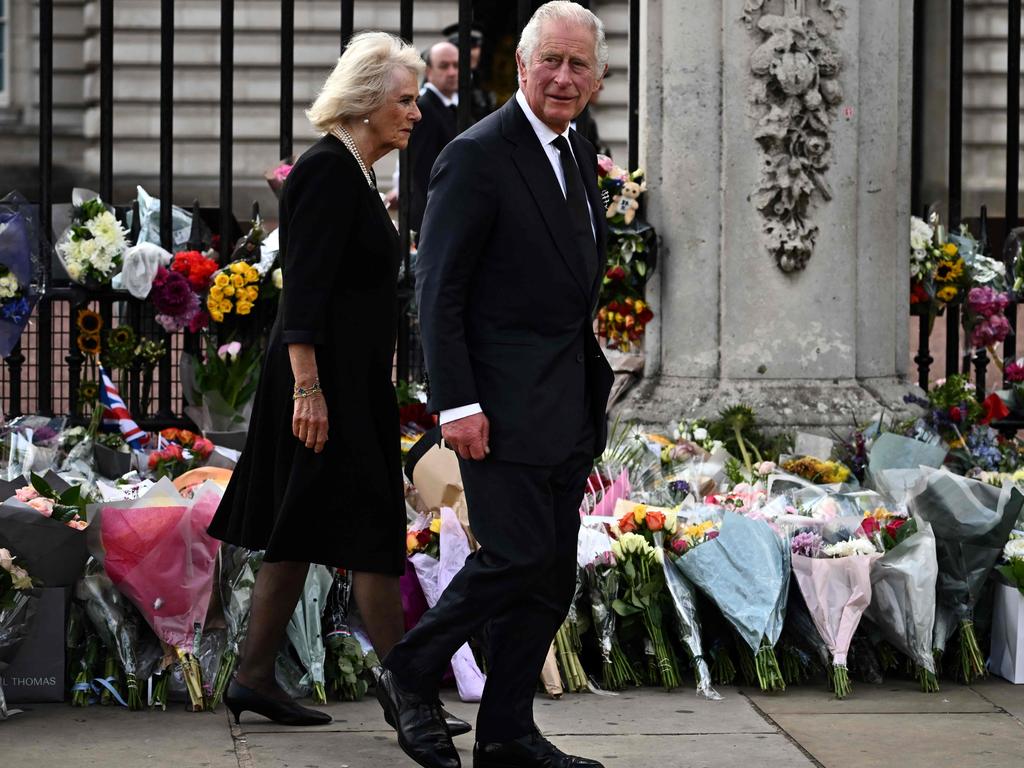 Britain's King Charles III and Camilla, Queen Consort walk past floral tributes to the Queen left outside of Buckingham Palace. Picture: AFP.