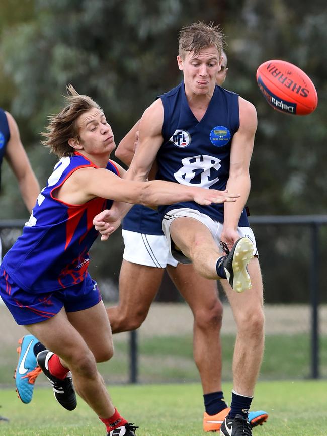 Leigh Judd gets a kick away under pressure from a Mernda opponent. 