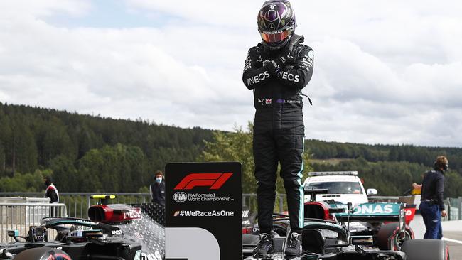 Mercedes' British driver Lewis Hamilton gestures as he stands on his car