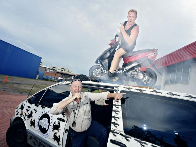 Dave Ramage and Dazza Ampt show off their Shitbox Rally entry, featuring a burnout scooter attached to the roof of a Tarago