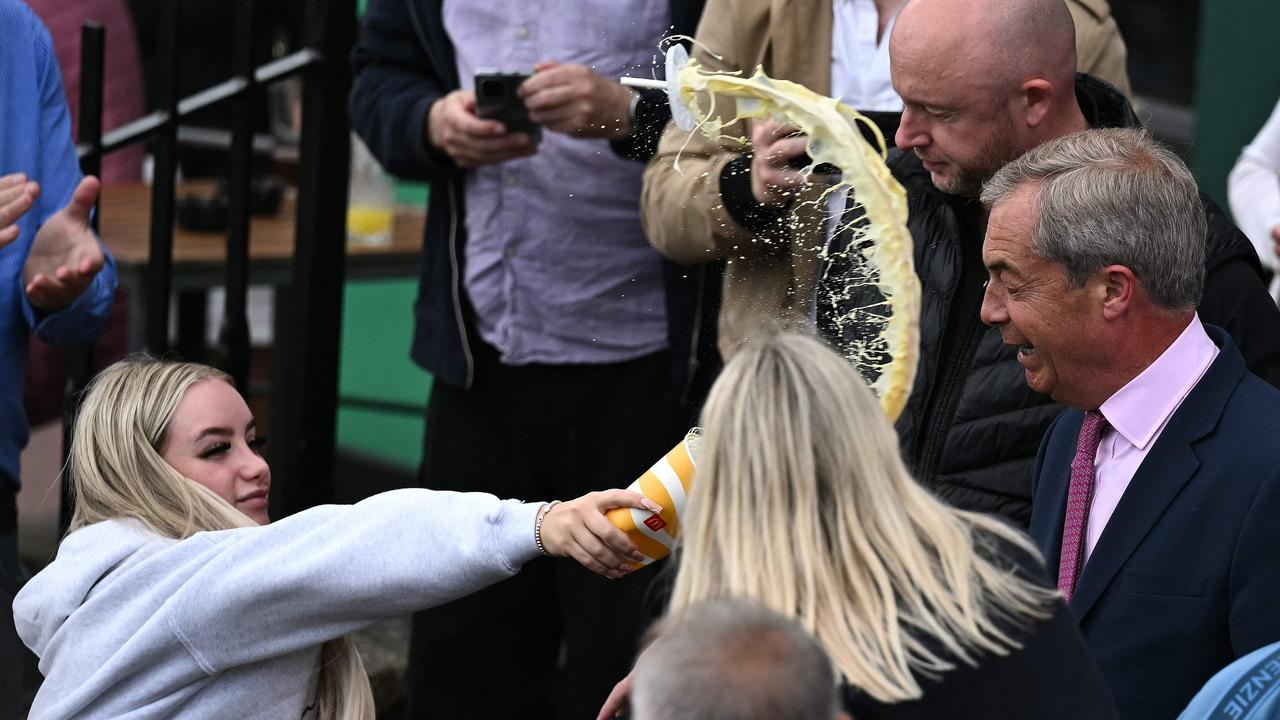 A woman throws a drink on Nigel Farage, the leader of Britain's right-wing populist party Reform UK. (Photo by Ben Stansall / AFP)