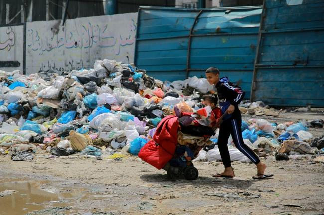 A child walks past a pile of household garbage in Gaza City -- the world's top court said 'famine is setting in'