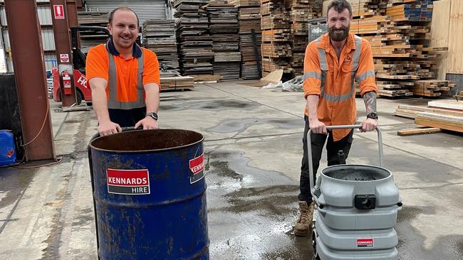 Liam Thompson and Dean Grayson continue the clean up at Kilmac Civil Construction, on July 5, 2022 after Milperra Road flooded. Picture: Paul Brescia