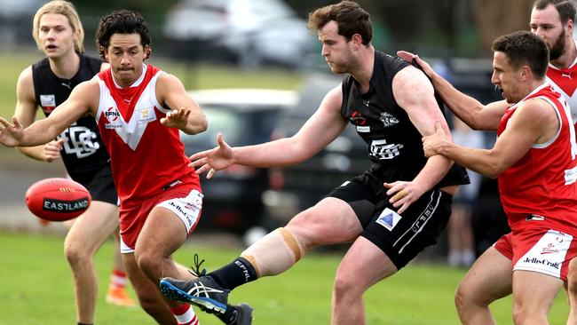 Zac Hanlen for East Burwood gets a kick under pressure. Picture: Stuart Milligan